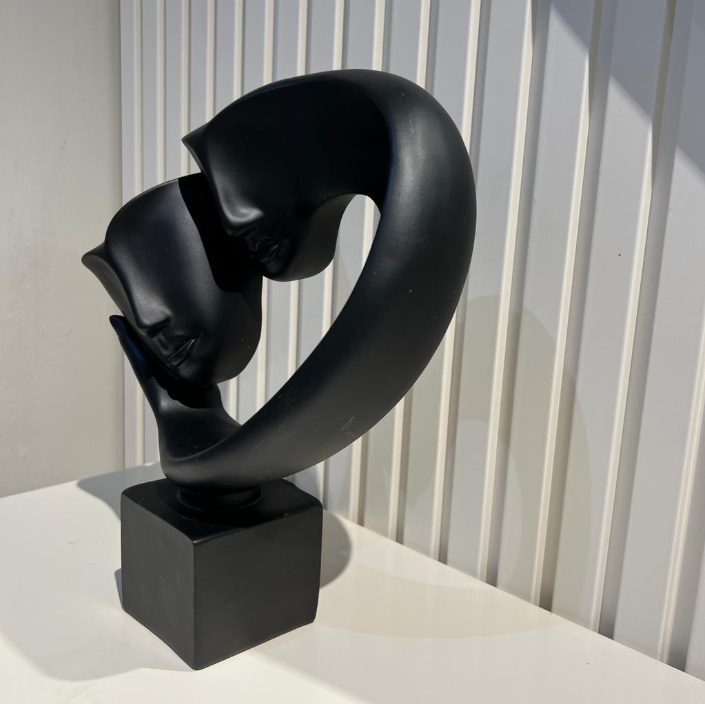 פסל מסכות על יד אבסטרקט שחור